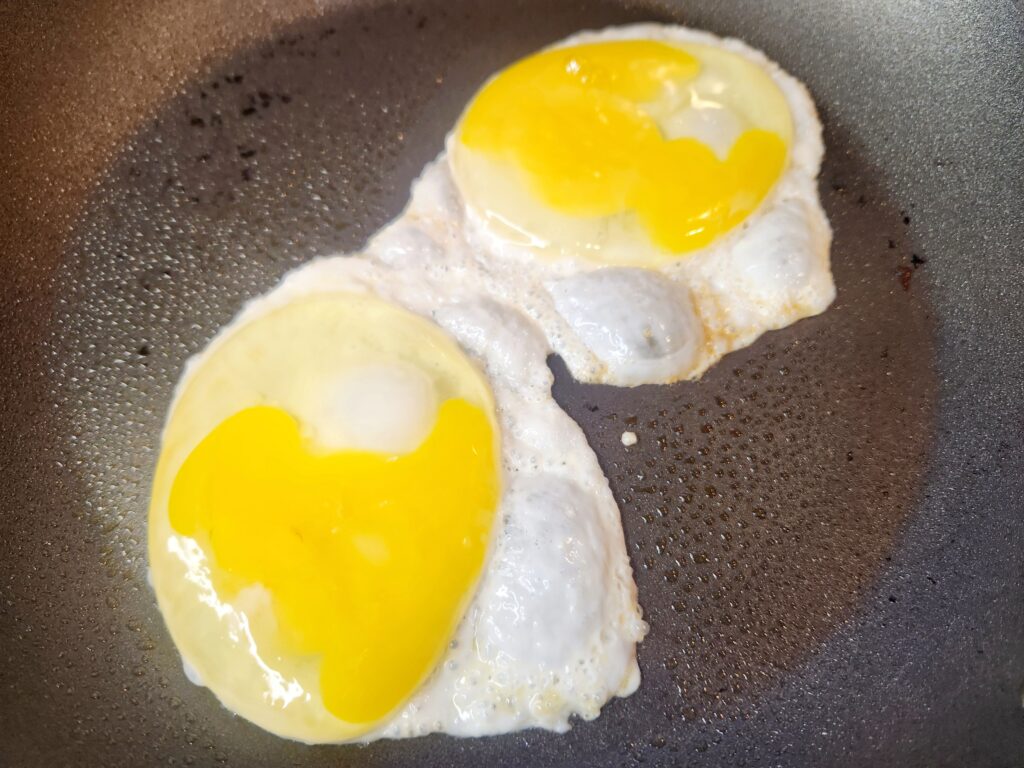 Frying eggs for Copycat Breakfast Jack