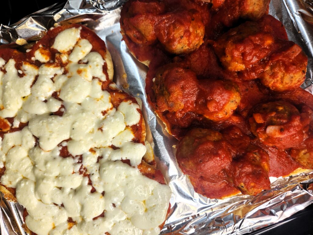 Awesome Meatball Sliders just out of the oven and displaying all the melty mozzarella cheesy goodness and our Perfect Turkey Meatballs smothered in marinara.
