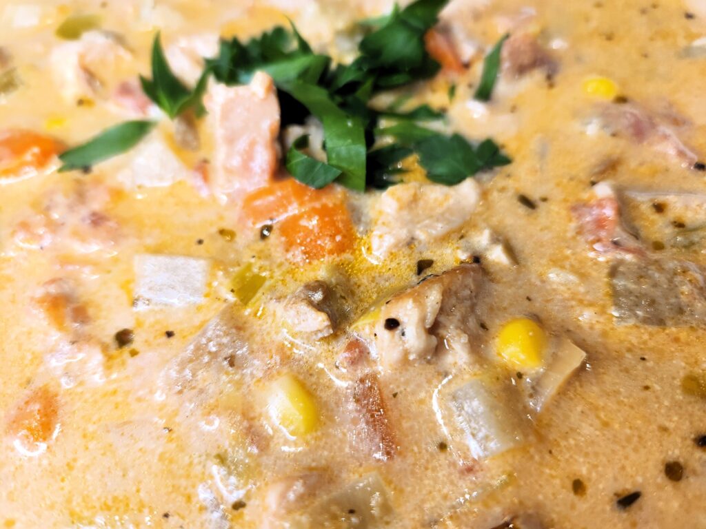 Close up of Chicken and Veggie Chowder with a parsley garnish.