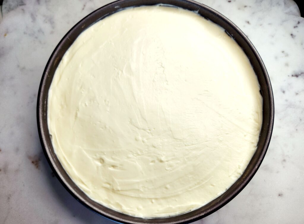 Springform pan filled with Graham Cracker Crust and Cream Cheese filling