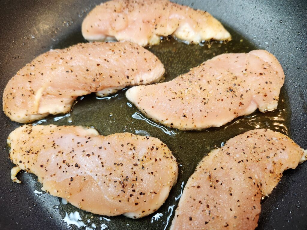 Pan Seared Chicken Tenderloins cooking on first side