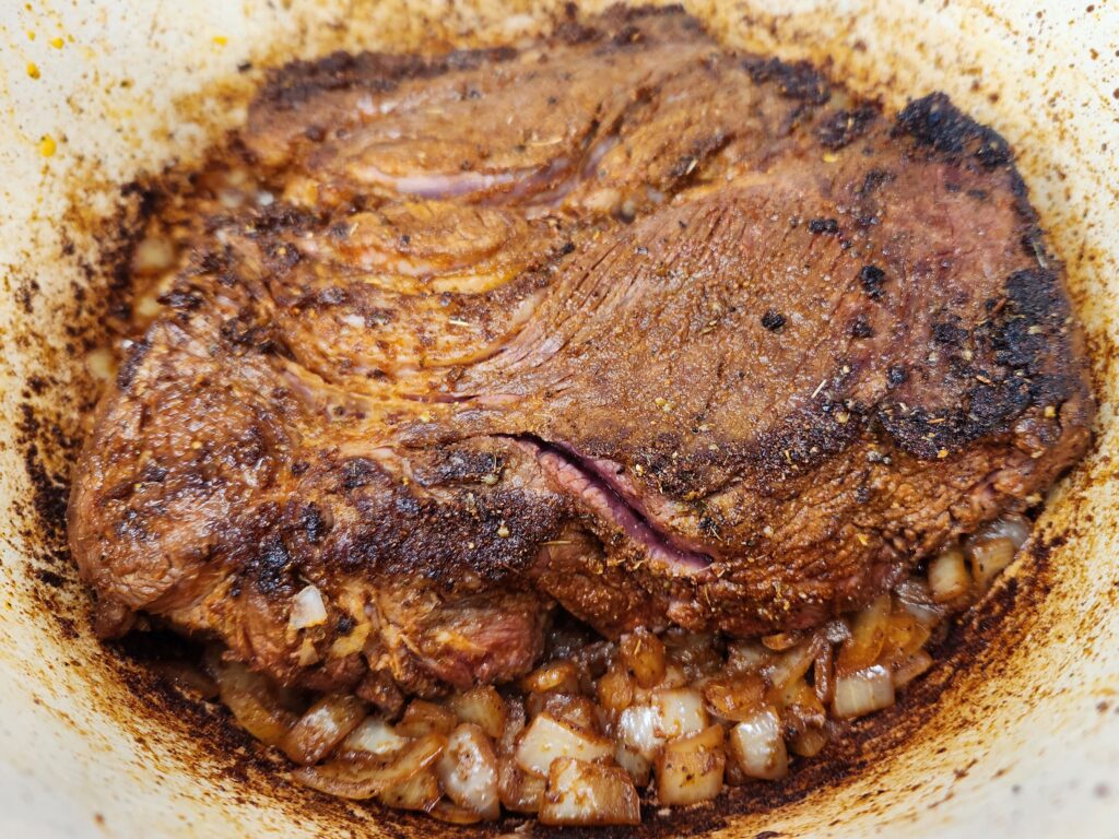Add seared roast to dutch oven for Smothered Chunky Beef Burritos
